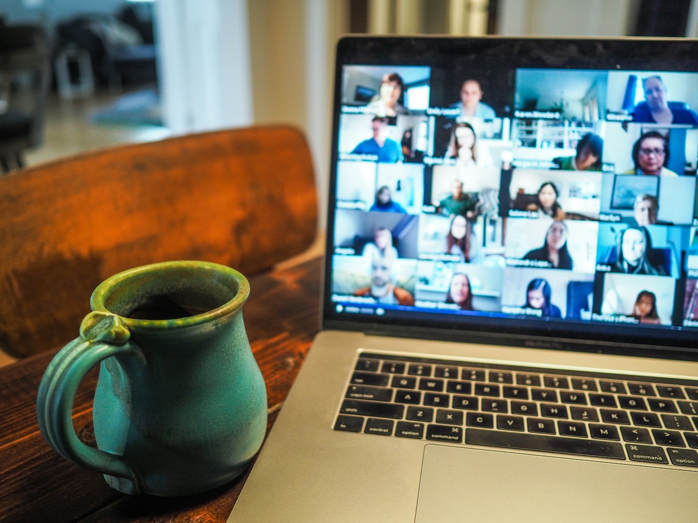 People collaborating over a video call on laptops around a table